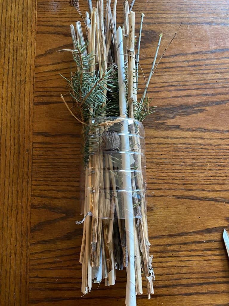 The tied natural materials inside the plastic water bottle tube.