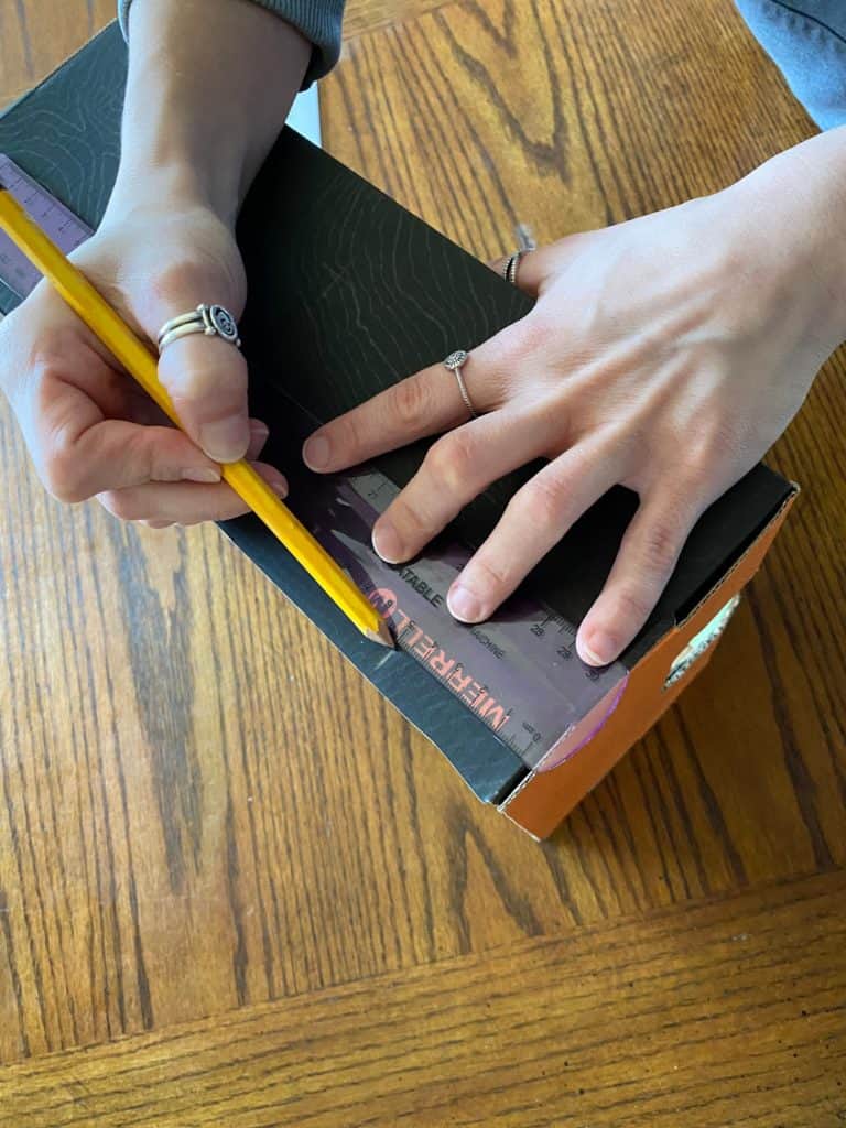 Using a ruler and pencil to mark out spacing for the rods.