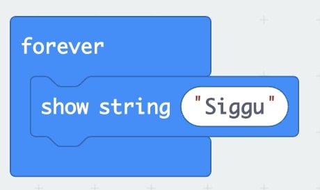 Close up of a ‘forever loop’ block with a ‘show string “Siggu” ’ block inside in MakeCode Arcade