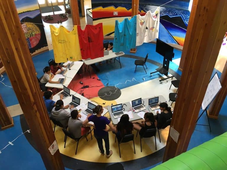 students on laptops sitting in a circle