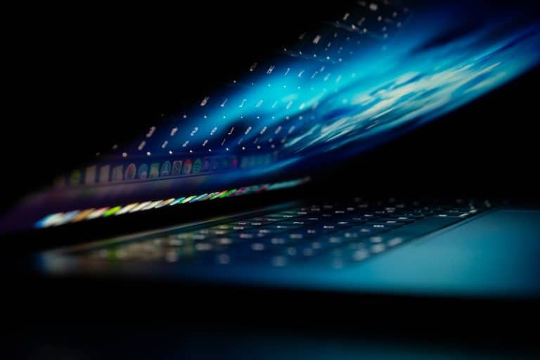 A laptop that is partially open with a glowing screen.