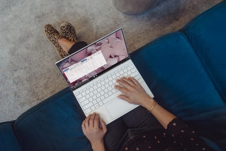 A person using a laptop, the camera view is faced down towards the persons lap.