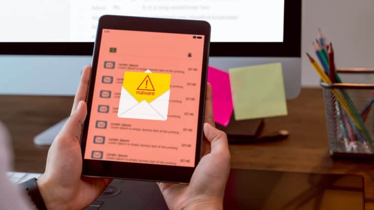 Person using a tablet device with an email message on-screen reading "malware".