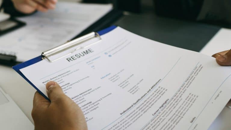 A person holding a printed resume.
