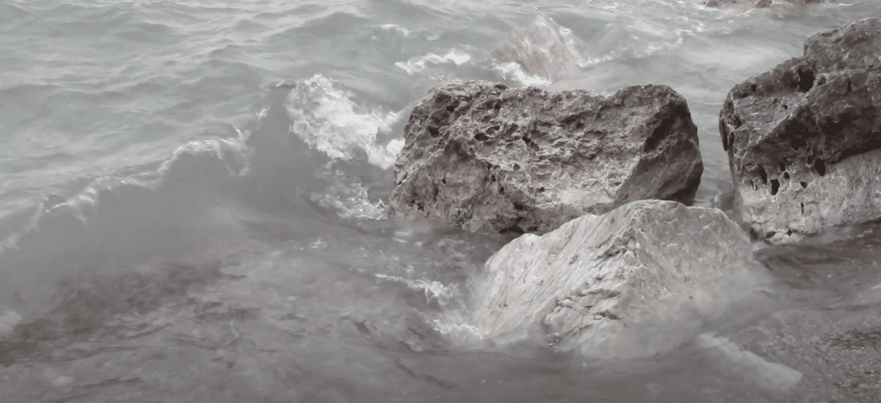 Rocks with water splashing up onto them.