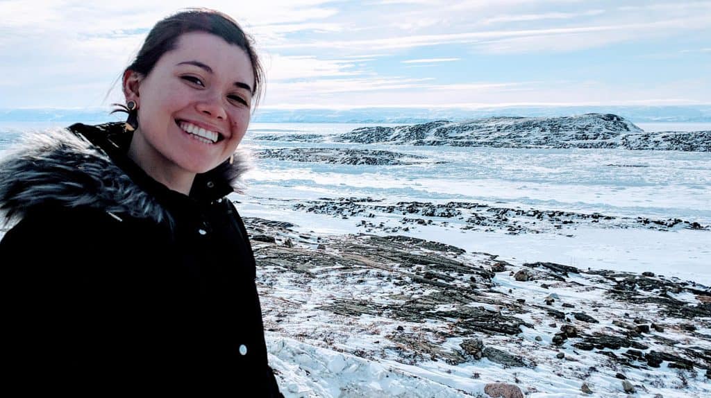 Danielle Moore standing in front of mountains smiling.