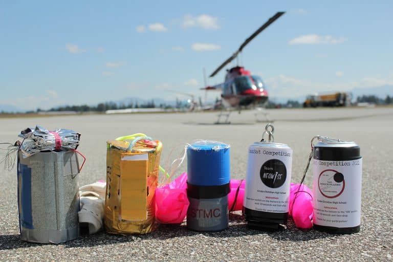 CanSats lined up on pavement, ready for launch! These CanSats were deployed from a helicopter in June 2021, at the conclusion of the inaugural competition
