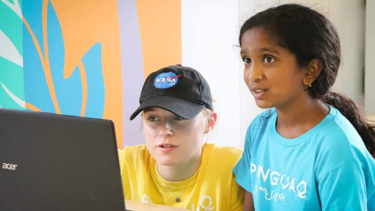 Two students working on a computer.