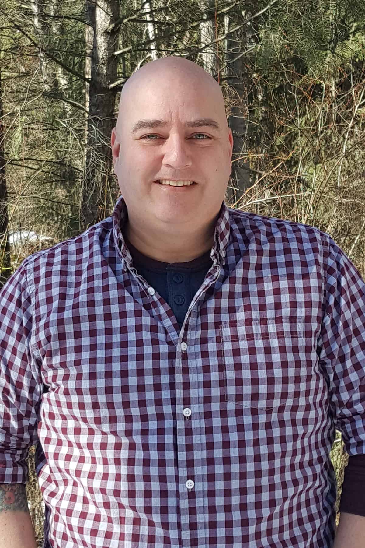 An image of Jon Corbett standing in the woods.